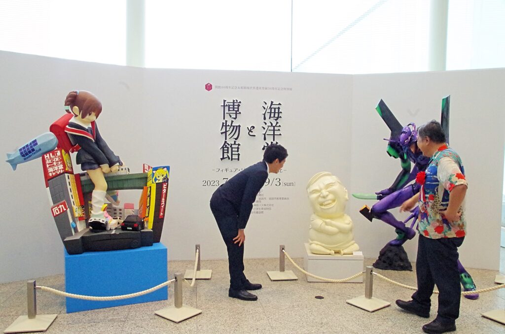 センム像を前に談笑する斎藤兵庫県知事（左）と宮脇専務（右）